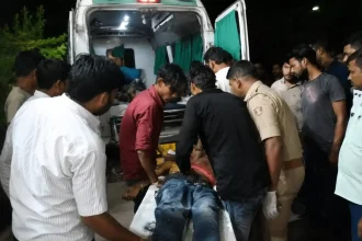 फिरोजाबाद के फरिहा क्षेत्र में ई-रिक्शा हादसे के बाद घायलों को एंबुलेंस से ट्रॉमा सेंटर ले जाते पुलिसकर्मी और स्थानीय लोग।